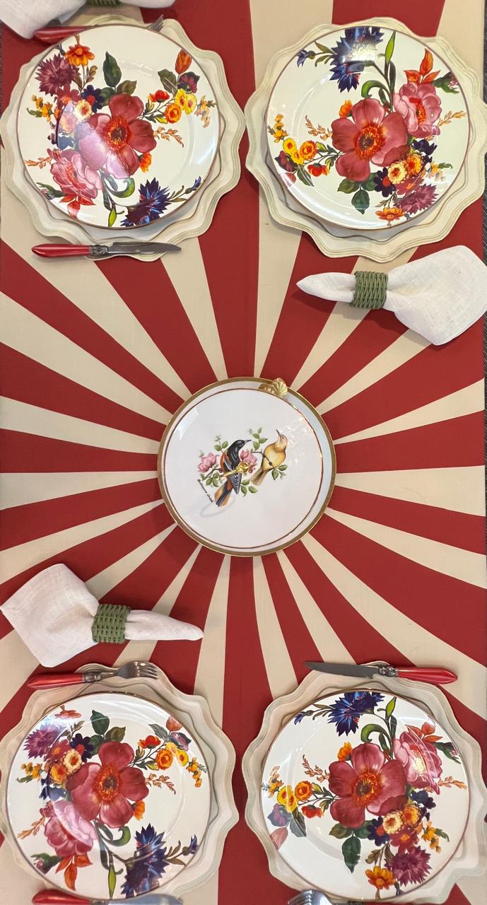 Mesa de otoño con mantel de rayos rojo y crema y platos florales